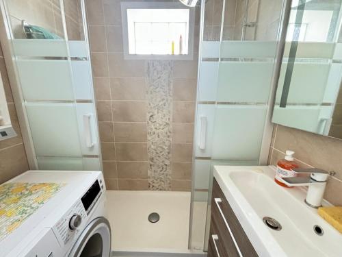une salle de bain avec une machine à laver et un lavabo dans l'établissement Appartement Confortable à 100m de la Plage, Centre-ville Les Sables-d'Olonne - FR-1-197-593, à Les Sables-dʼOlonne