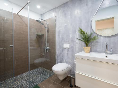 a bathroom with a shower and a toilet and a sink at Pasito Blanco Villas in Pasito Blanco