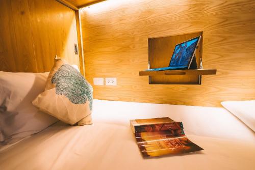 a bedroom with a bed with a laptop on it at THALAY Cha-am by THA in Cha Am