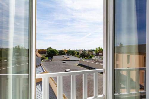 a view from the balcony of a building at Hôtel De La Plage in Courseulles-sur-Mer