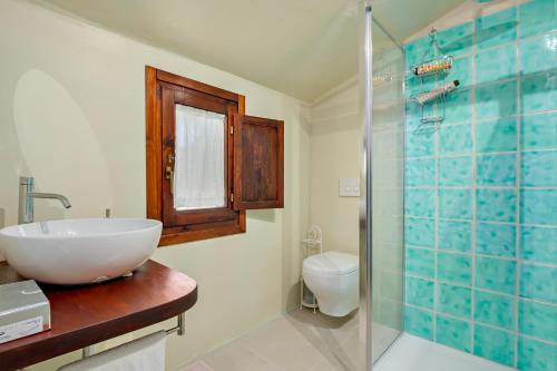 a bathroom with a sink and a glass shower at Stazzu Straetu in Olbia