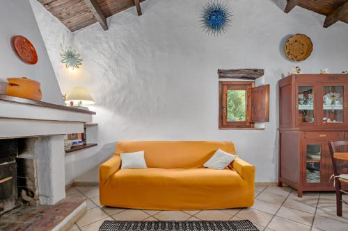um sofá amarelo numa sala de estar com lareira em Stazzu Straetu em Olbia