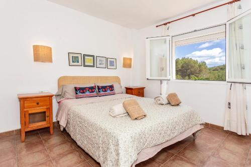 a bedroom with a bed and a window at Son Bou by the Sea in Alaior