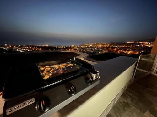 a grill with a pan of food on top of a city at Vila Ocean View Tenerife in Adeje