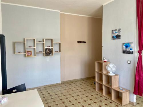 una camera con una parete bianca, scaffali e un tavolo di Da Lumi Relax a Lanzo Torinese
