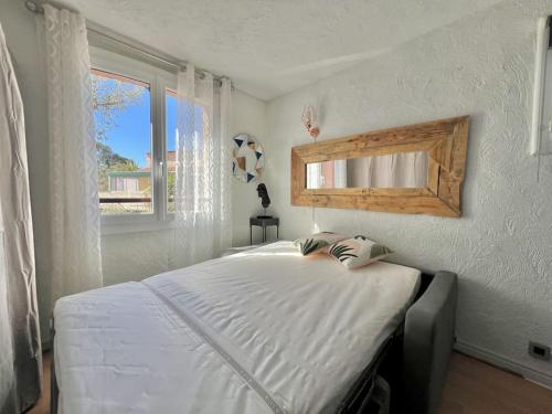 une chambre avec un grand lit blanc avec une fenêtre dans l'établissement Studio duplex proche mer gare commerce, à Saint-Raphaël