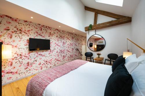 1 dormitorio con 1 cama y una pared cubierta de flores en Maison d'Hôtes "Les Bulles Dorées" en Rilly-la-Montagne