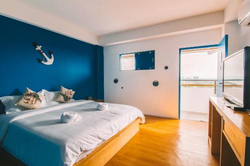 a bedroom with a bed with a blue wall at THALAY Cha-am by THA in Cha Am