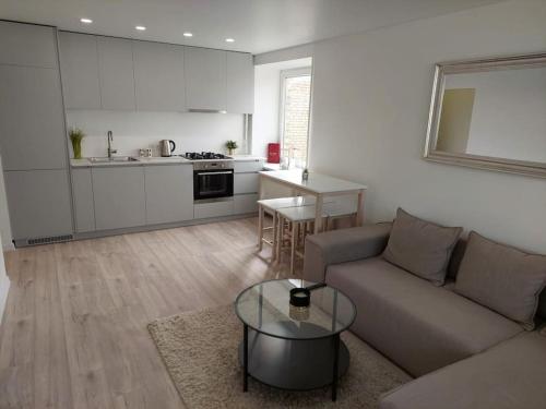 a living room with a couch and a table and a kitchen at Central w/free parking & Netflix in Vilnius