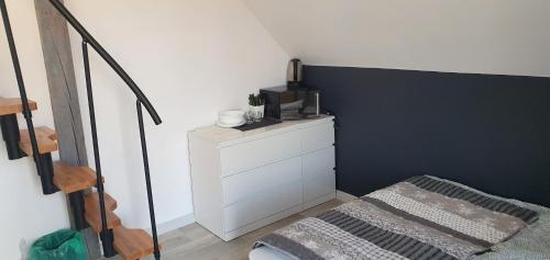 a bedroom with a white dresser and a black accent wall at Apartamenty i pokoje TT Mielno ALLDAYHOLIDAY in Mielno