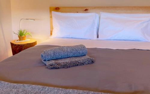 Una cama con una almohada azul encima. en Sweet Quintanilha 