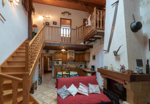 - un salon avec un escalier et un canapé rouge dans l'établissement Gîte des Fées, à Pretin