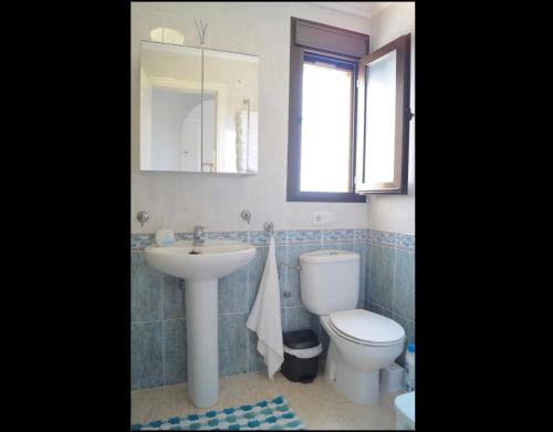 ロハレスにあるAcogedor apartamento con vistasのバスルーム(トイレ、洗面台付)、窓が備わります。