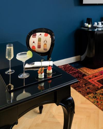 a black table with two glasses and desserts on it at Arté Boutique Hotel in Tirana
