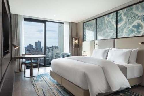 a bedroom with a large white bed and a large window at The Westin Istanbul Nisantasi in Istanbul