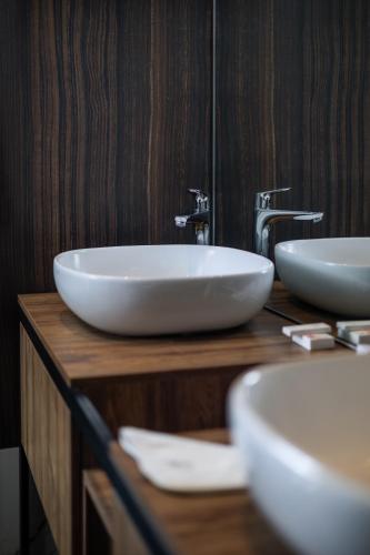 a bathroom with two sinks on a wooden counter at Arté Boutique Hotel in Tirana
