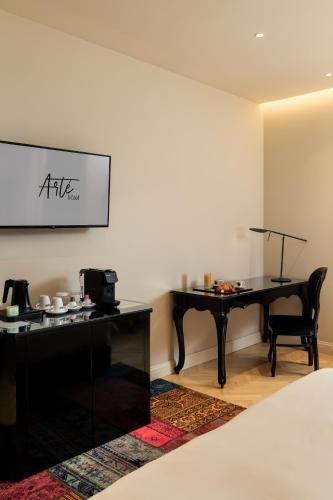 a room with a desk and a table with a piano at Arté Boutique Hotel in Tirana