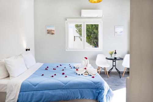 a bedroom with a blue bed with red hearts on it at Aegean Blue Santorini Perissa in Perissa
