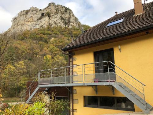a house with a balcony with a mountain in the background at Gîte des Fées in Pretin
