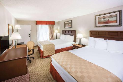 a hotel room with two beds and a desk at Baymont by Wyndham Mobile/ I-65 in Mobile