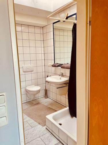 a bathroom with a toilet and a sink and a tub at Top Lage, Frankfurt Westend-Süd in Frankfurt