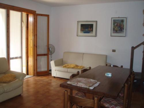 een woonkamer met een tafel en een bank bij VILLA ORATA 8b in Principina a Mare