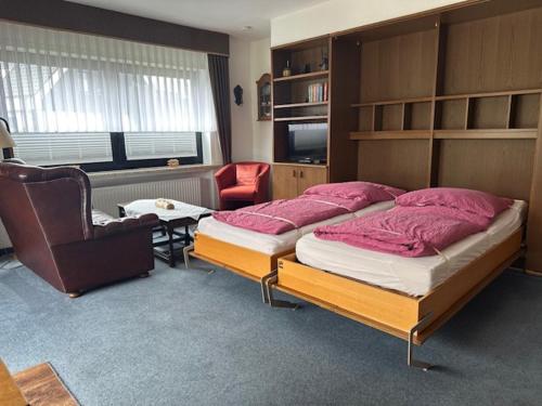 ein Schlafzimmer mit einem großen Bett und einem Stuhl in der Unterkunft Ferienhaus Heyder in Norderney