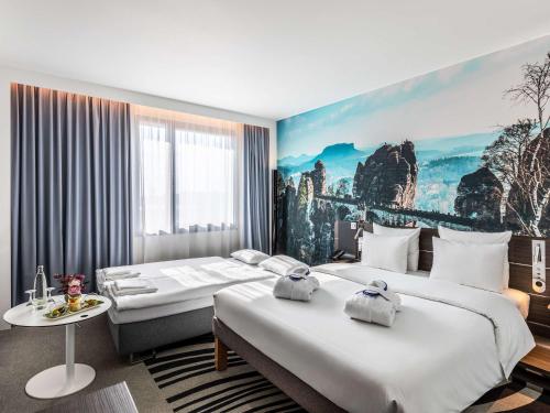 a hotel room with two beds and a painting on the wall at Novotel Hamburg City Alster in Hamburg
