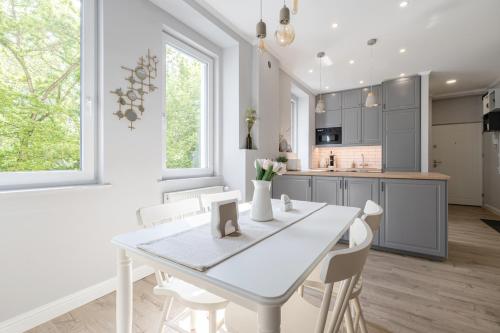 a white kitchen with a white table and chairs at Eden Enchantment Apartment in Budapest
