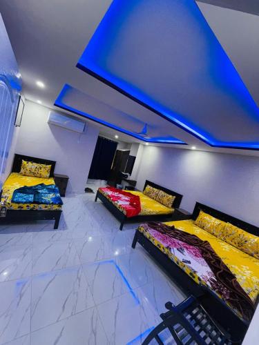 two beds in a room with a blue ceiling at Moven Inn Hotel Islamabad in Islamabad