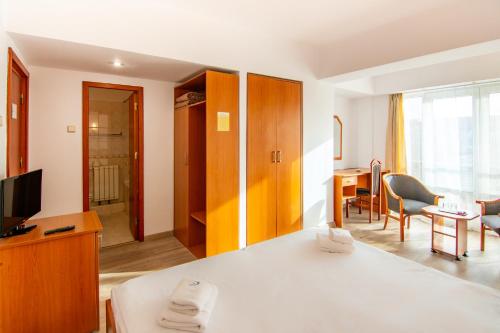 une chambre d'hôtel avec un lit et une salle à manger dans l'établissement Villa Caprice, à Constanţa