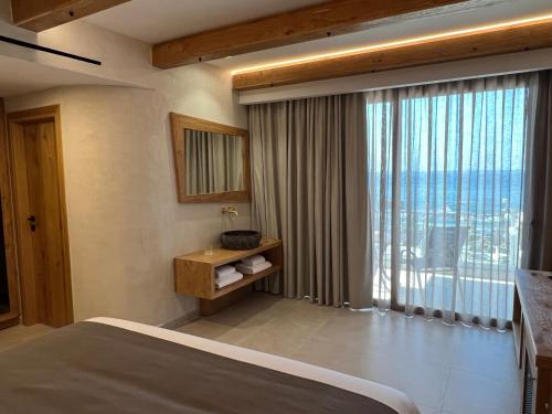 ein Schlafzimmer mit einem Bett und einem großen Fenster in der Unterkunft CHC Atlantida Mare in Agia Marina