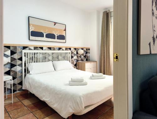 una camera da letto con un letto con due asciugamani sopra di Flats Friends Nave a Valencia