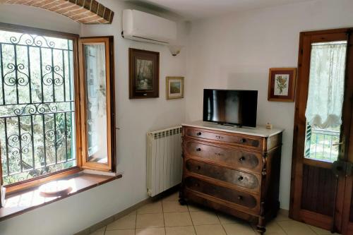 Una habitación con un tocador con una TV encima. en Appartamento rustico nel cuore di San Baronto, en San Baronto