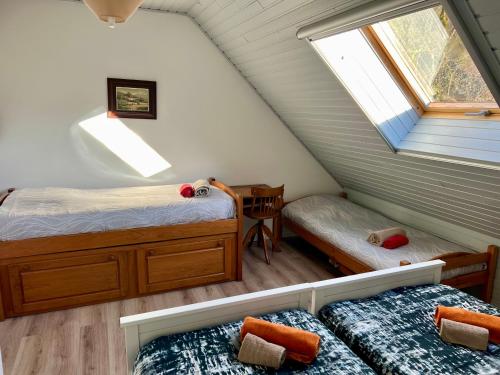 a attic bedroom with two beds and a window at Gîte des Fées in Pretin