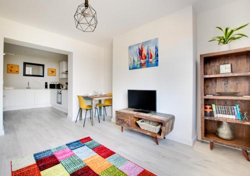 a living room with a television and a table at Phoebe’s - Ellinbrook Apartments in Hunstanton