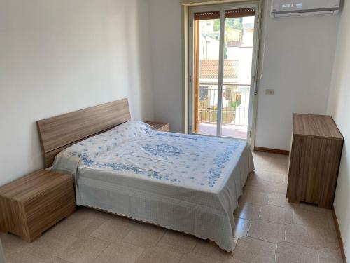 1 dormitorio con 1 cama y 2 mesas de madera en LA FINESTRA SUL MARE, en Ali Terme