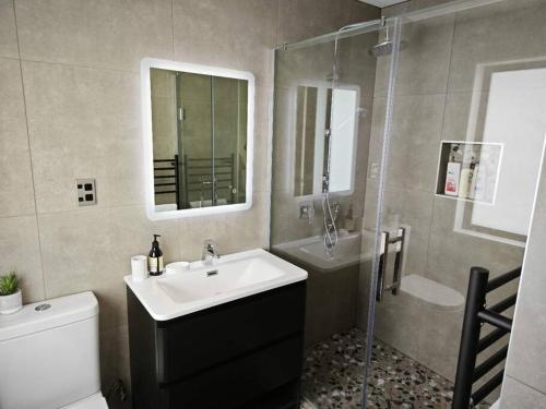 a bathroom with a sink and a toilet and a shower at Brand New & Central - 3 Bedrooms with 3 En suites in Auckland