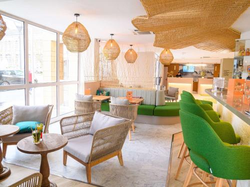 a living room with green chairs and a table at ibis Styles Tours Centre in Tours