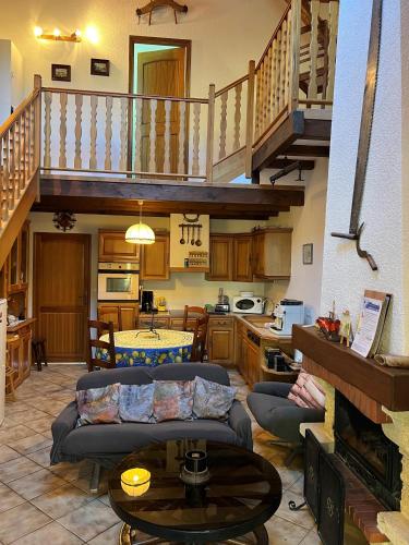 a large living room with a staircase and a table at Gîte des Fées in Pretin