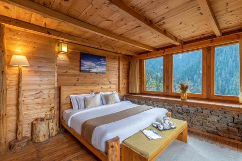a bedroom with a bed in a log cabin at ELIVAAS 4 BHK with Garden & Sauna - Skylounge in Shimla