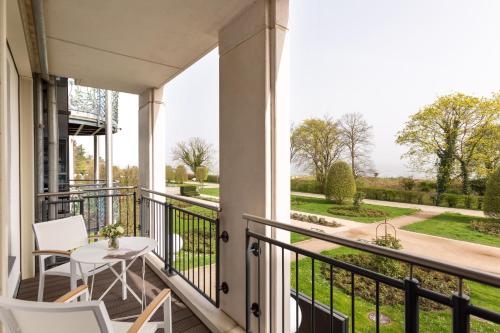 einen Balkon mit einem Tisch und Stühlen sowie Blick auf einen Hof in der Unterkunft Hotel Kaiserhof Heringsdorf in Heringsdorf