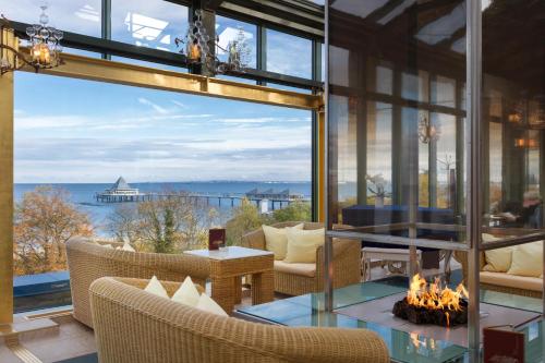 a room with a fireplace and a view of the ocean at Hotel Kaiserhof Heringsdorf in Heringsdorf