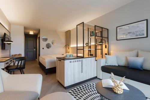 a living room with a couch and a bed at Hotel Kaiserhof Heringsdorf in Heringsdorf