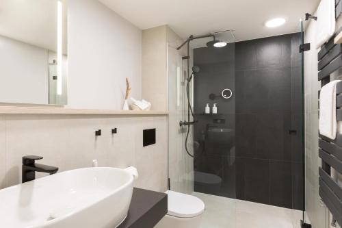 a bathroom with a shower and a sink and a toilet at Hotel Kaiserhof Heringsdorf in Heringsdorf