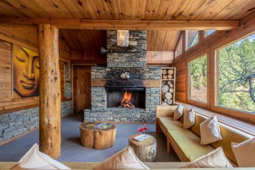 Cabaña de madera con sala de estar con chimenea en Elivaas Skyline Luxury 4BHK Entire Home in Narkanda, en Shimla