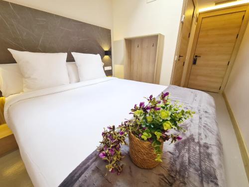 a white bed with a basket of flowers on it at Hotel Casa Gardenia in Barcelona