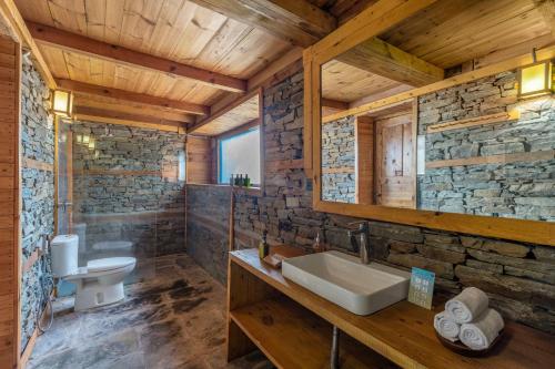 a bathroom in a log cabin with a sink and a mirror at ELIVAAS 4 BHK with Garden & Sauna - Skylounge in Shimla