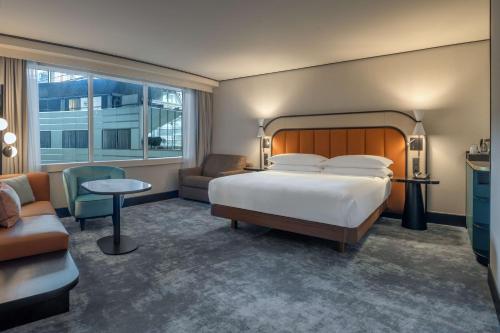 a bedroom with a bed and a couch and a chair at Hilton Paris La Défense in Puteaux