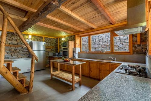 a kitchen with wooden ceilings and a wooden table at ELIVAAS 4 BHK with Garden & Sauna - Skylounge in Shimla